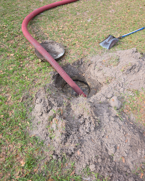 Septic tank pump-out with vacuum hose in a residential yard